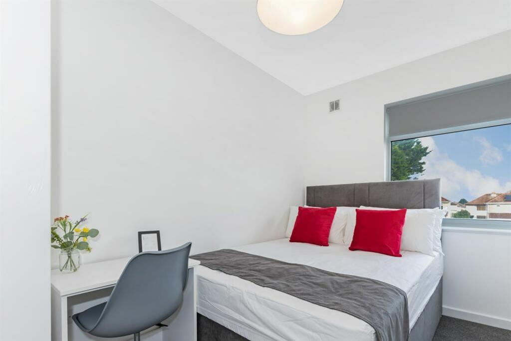 A clean and well-lit double bedroom featuring a...