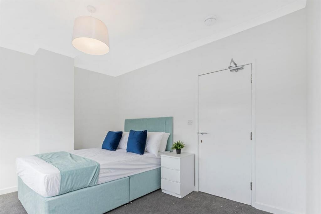 A clean and well-lit double bedroom with a comf...