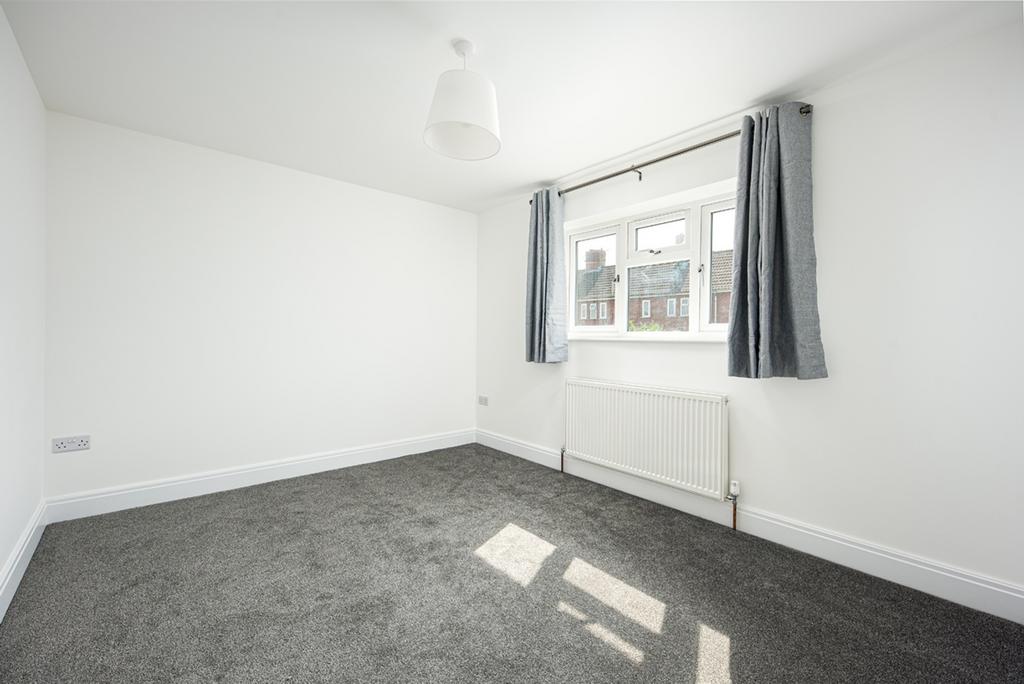 A clean and well-lit double bedroom with a larg...