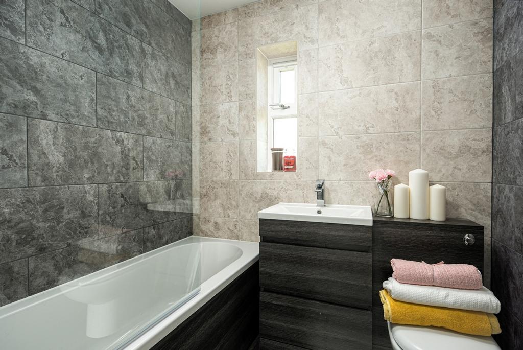 A clean and modern bathroom featuring a bath an...