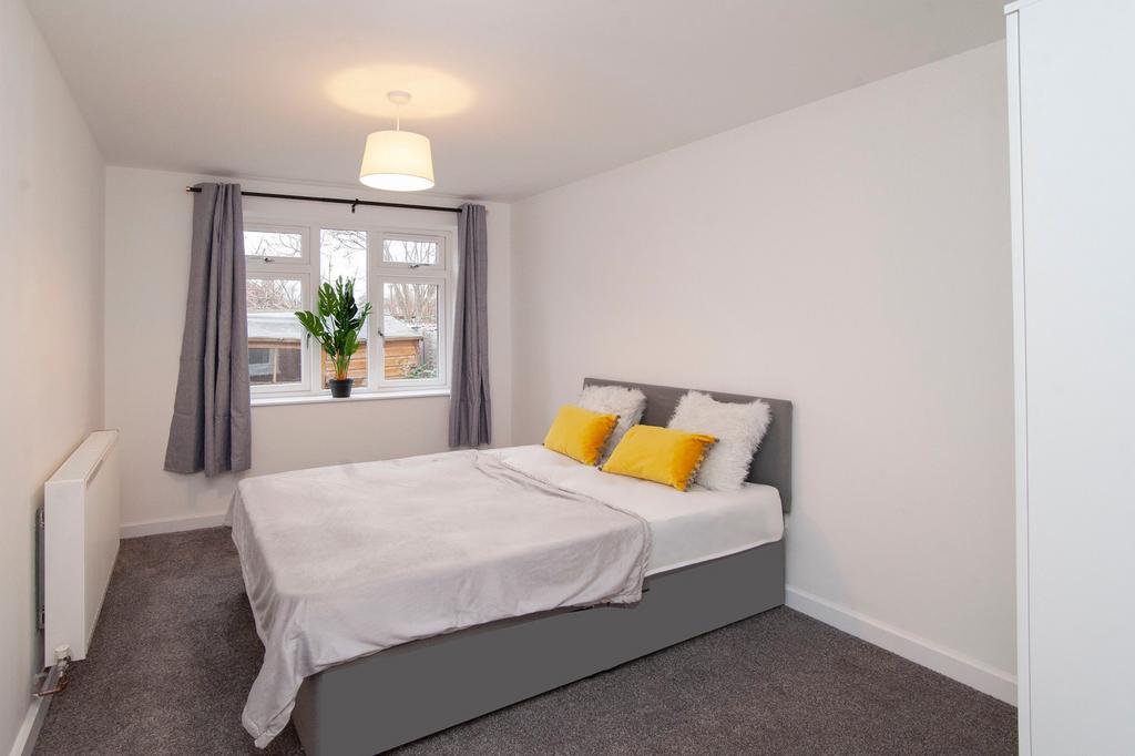 A clean and inviting double bedroom with large ...