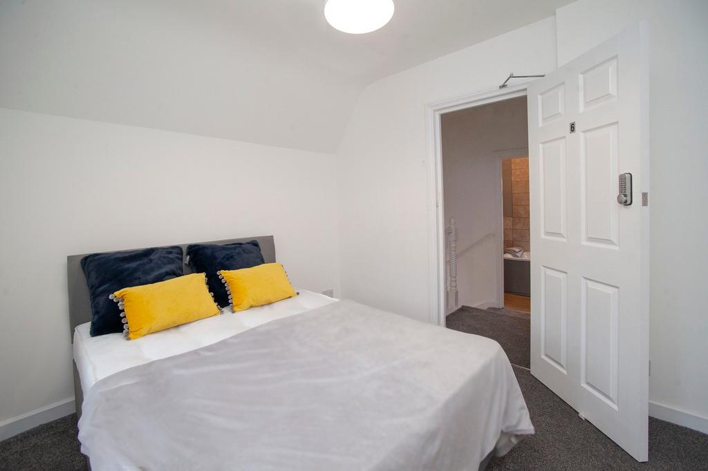 A tidy double bedroom featuring a bed with yell...