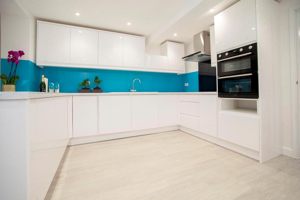 A modern and clean kitchen with bright blue acc...