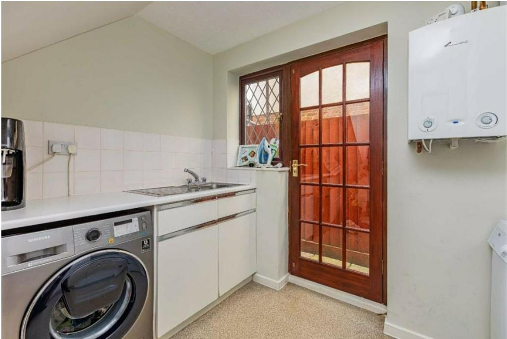 A tidy kitchen with a washing machine and natur...