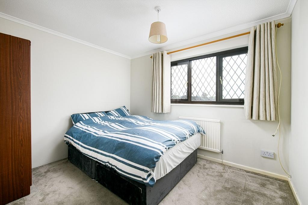 A tidy double bedroom with natural light from a...