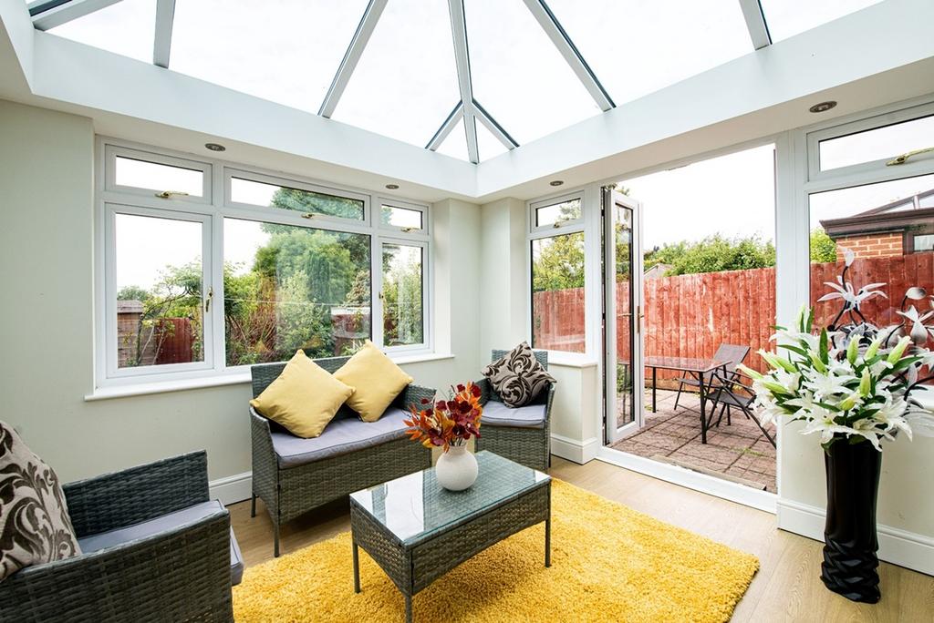 A bright and inviting garden room with large wi...