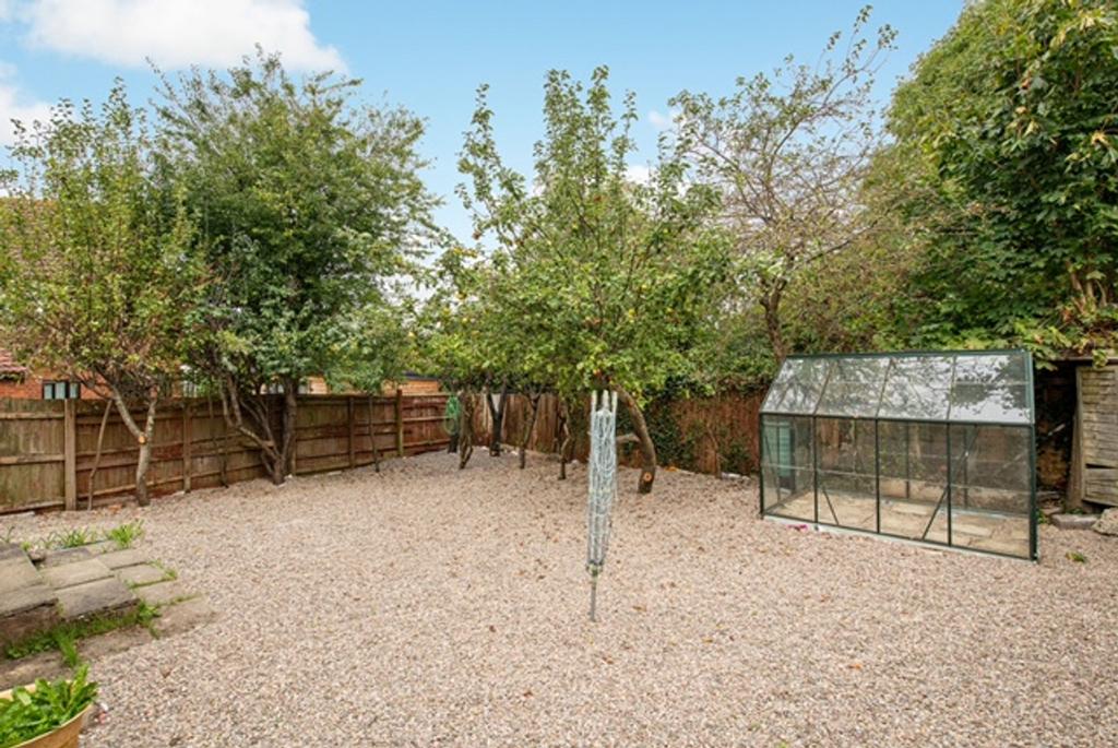 A spacious and well maintained garden with tree...