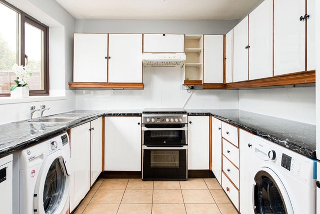 A clean and well-lit kitchen with modern applia...