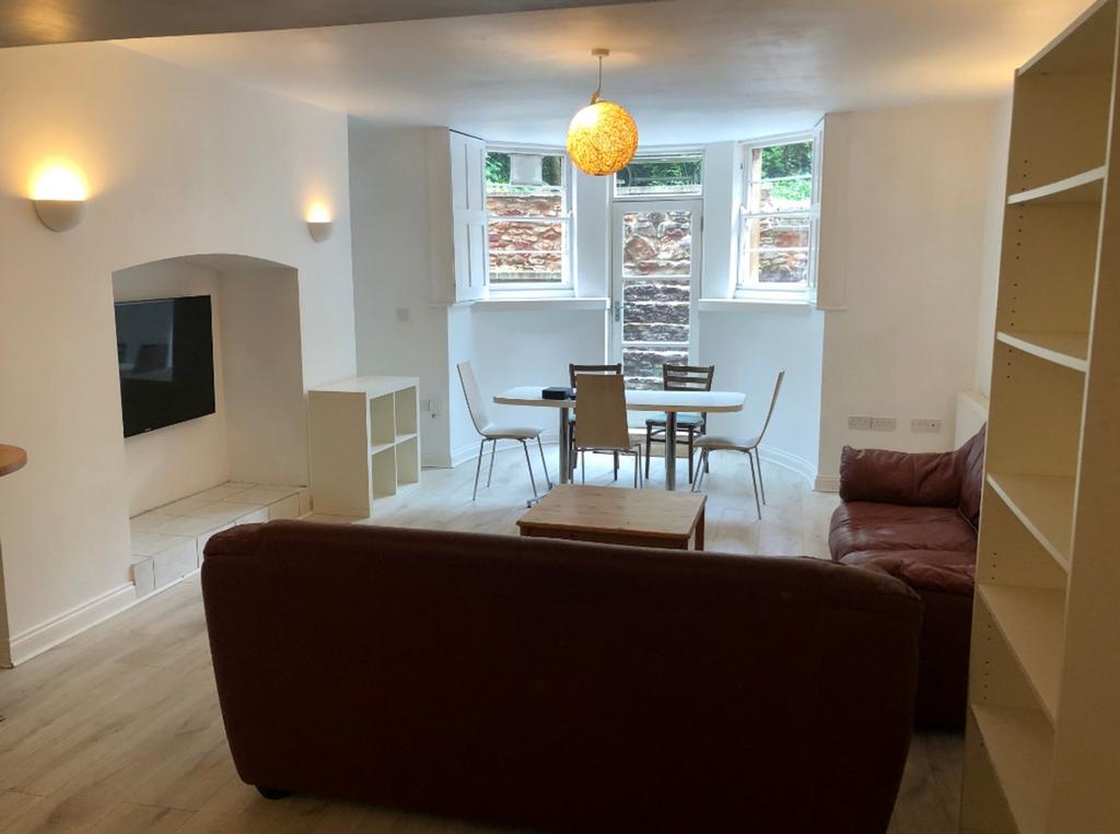 A spacious and well-lit living room featuring a...