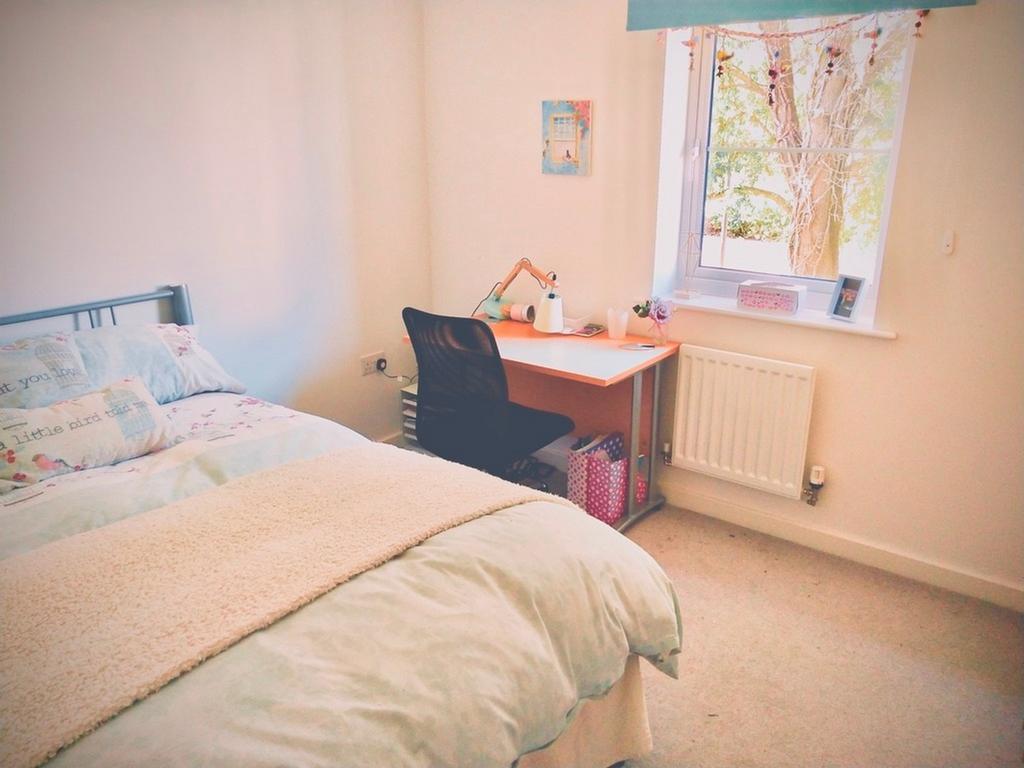 A bright and inviting double bedroom with a coz...