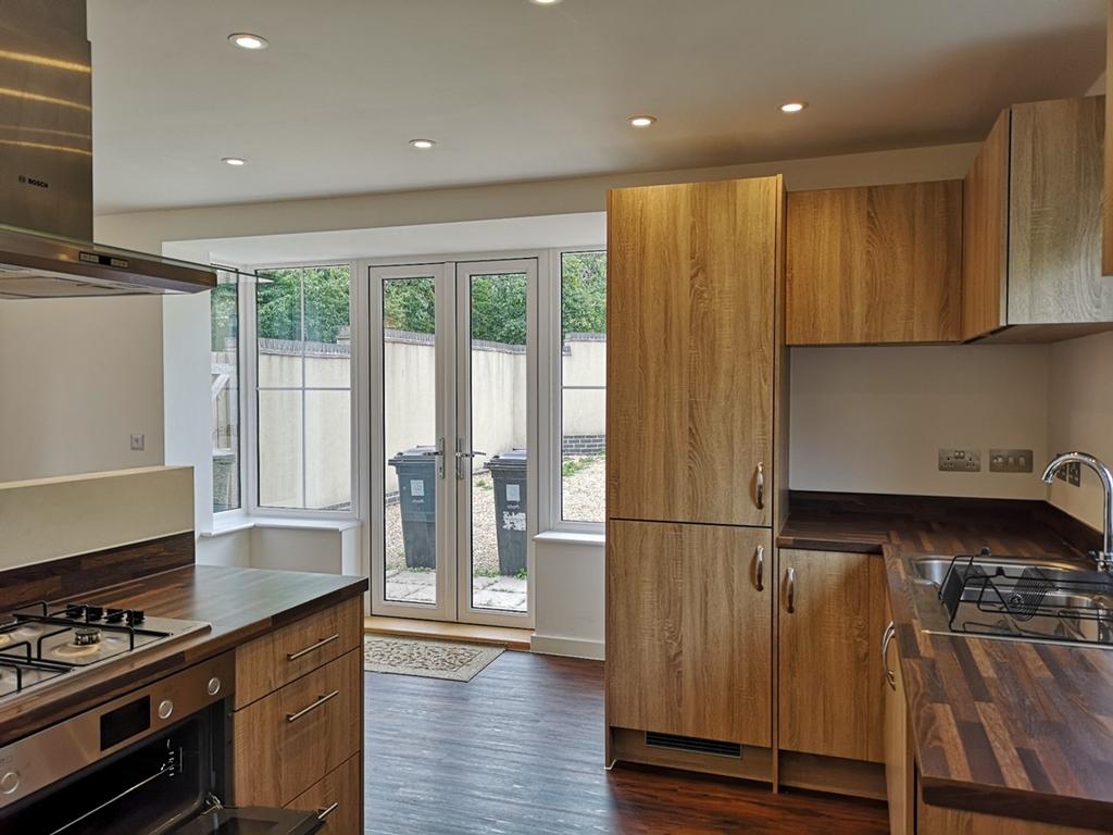 A bright and modern kitchen featuring ample sto...