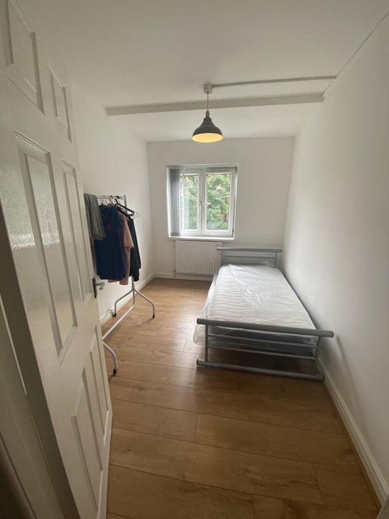 A tidy and well-lit single bedroom with ample n...