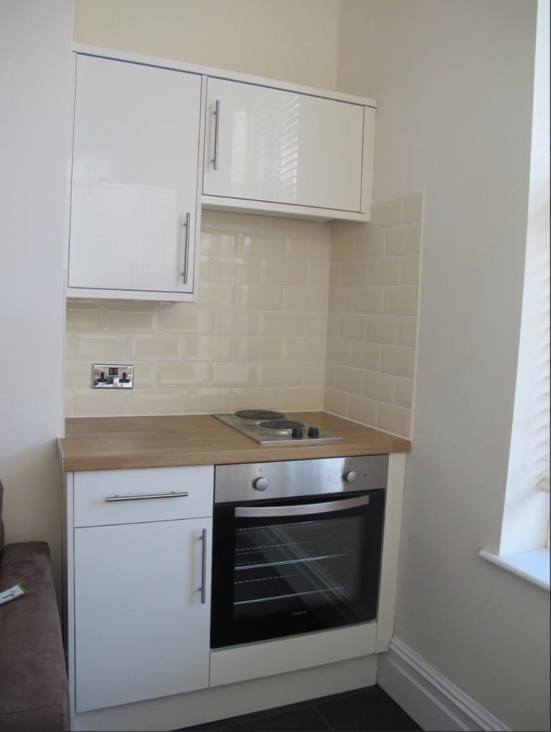 A modern and tidy kitchen featuring sleek cabin...