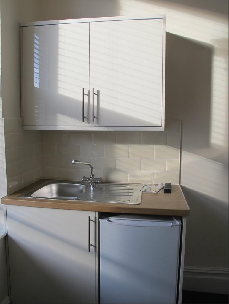 A bright and tidy kitchen featuring modern cabi...