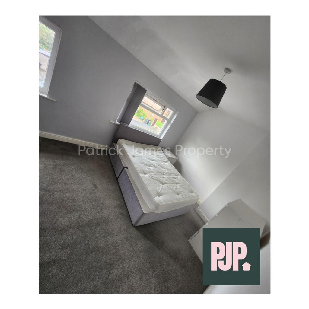 A spacious and well-lit double bedroom, ideal f...