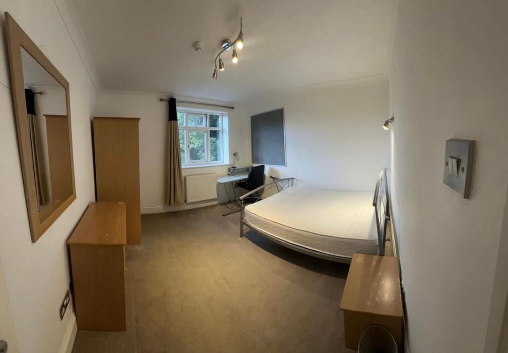 A spacious and well lit double bedroom featurin...