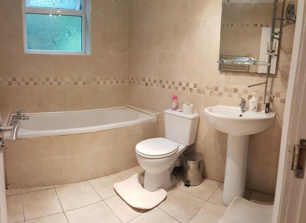 A spacious and clean bathroom featuring a bath,...