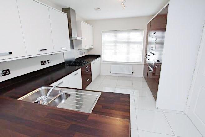 Bright, modern kitchen with dark wood worktops,...