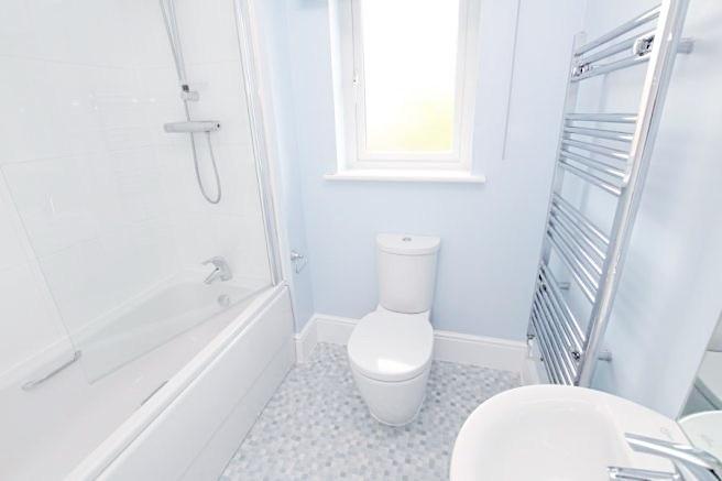 Bright, modern bathroom with a combined bath an...