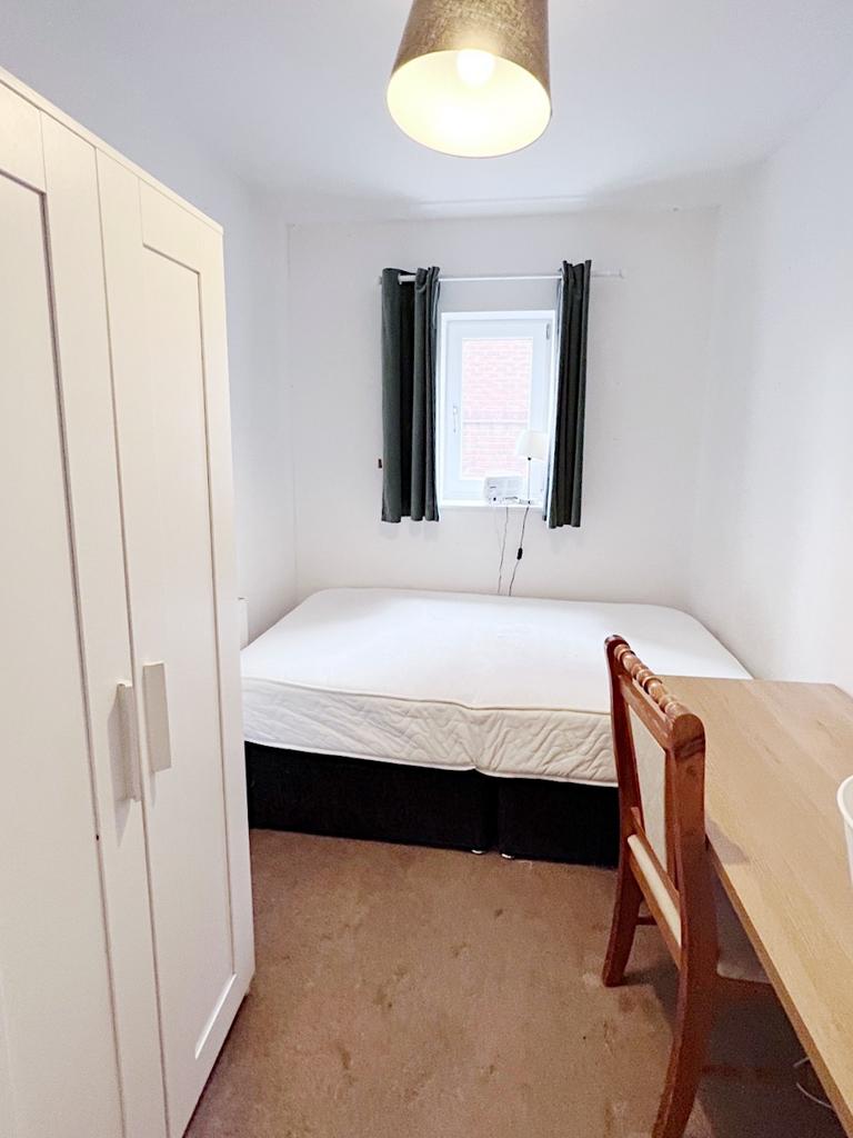 Compact furnished bedroom with a double bed, wa...