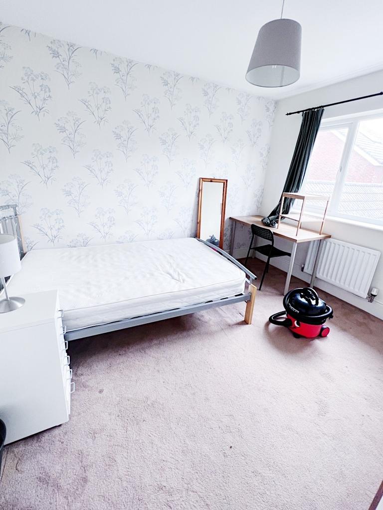 Bright, simply furnished bedroom with a single ...
