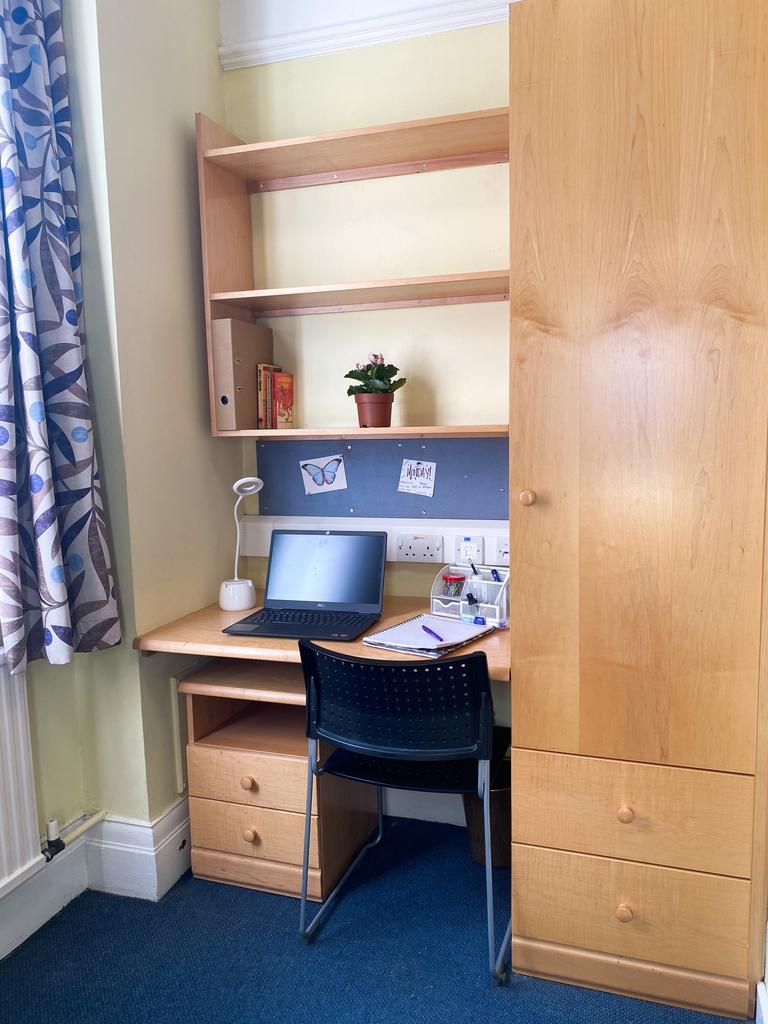 A tidy study area featuring a desk and shelving...