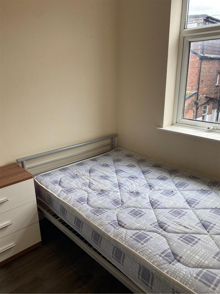 A bright and tidy single bedroom featuring a co...