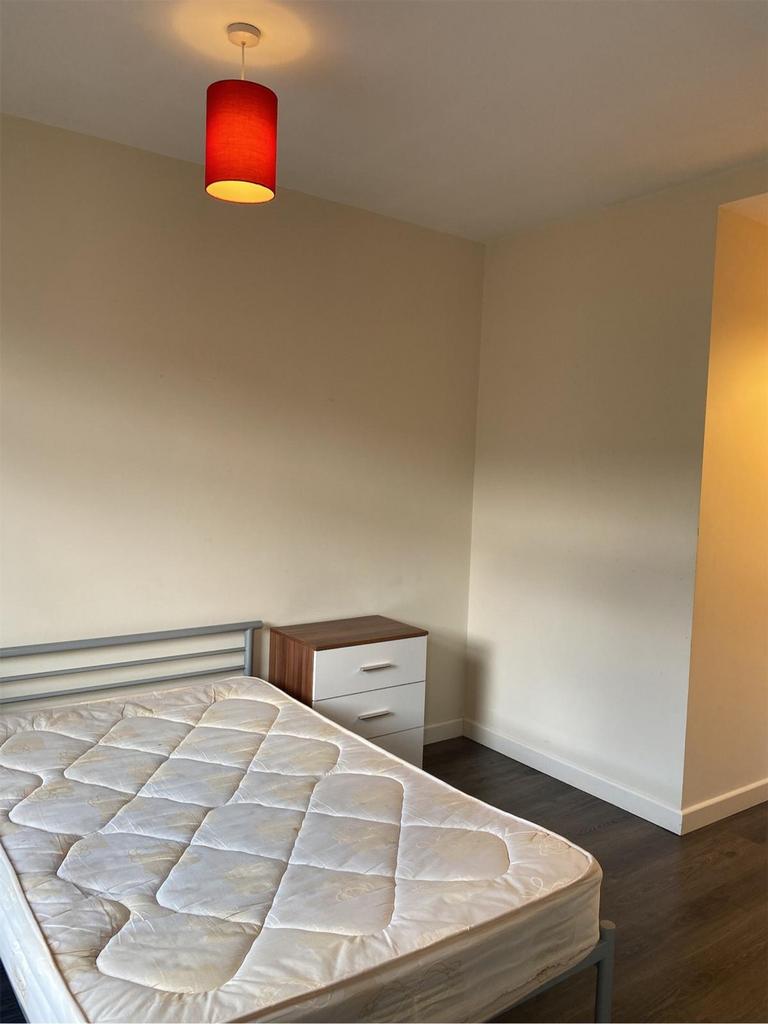 A spacious double bedroom with a modern aesthet...