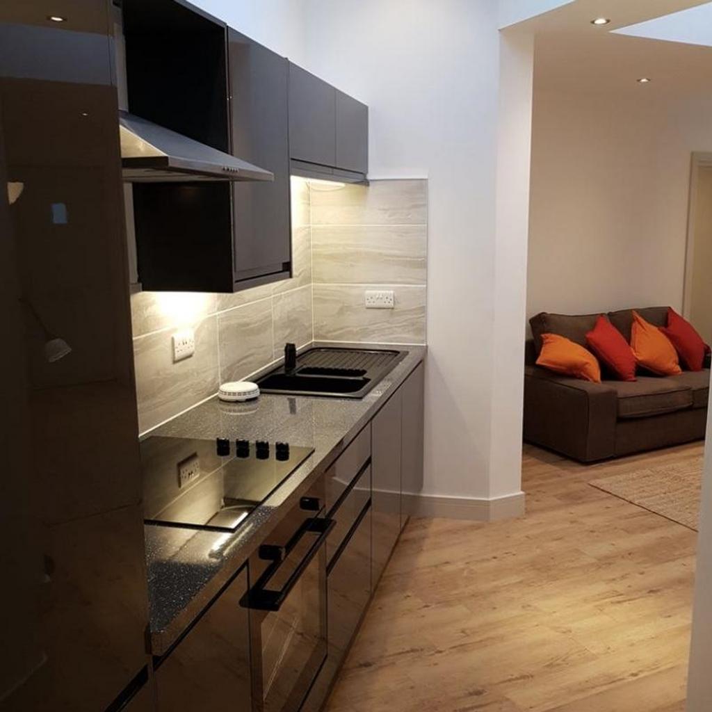 A stylish and modern kitchen with ample lightin...