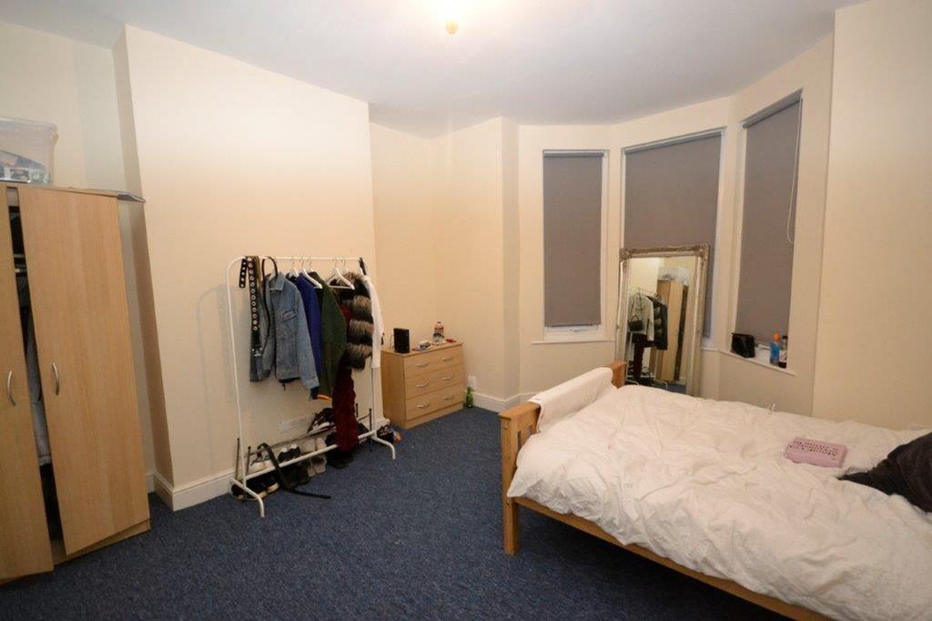 A tidy double bedroom featuring a bed, wardrobe...