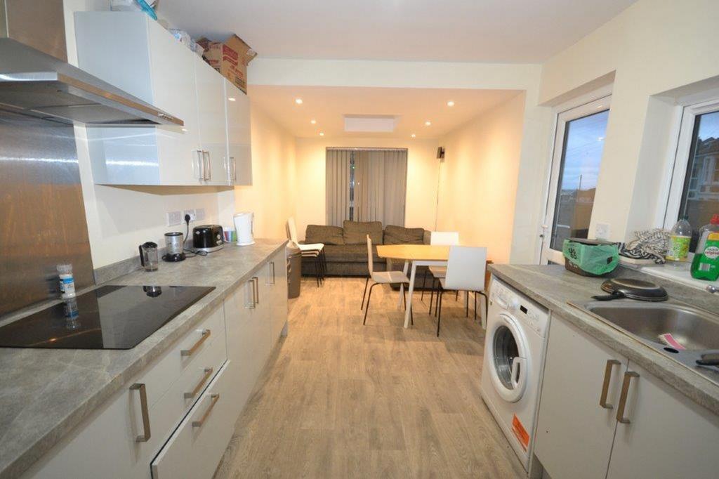 A modern kitchen with a dining area, featuring ...