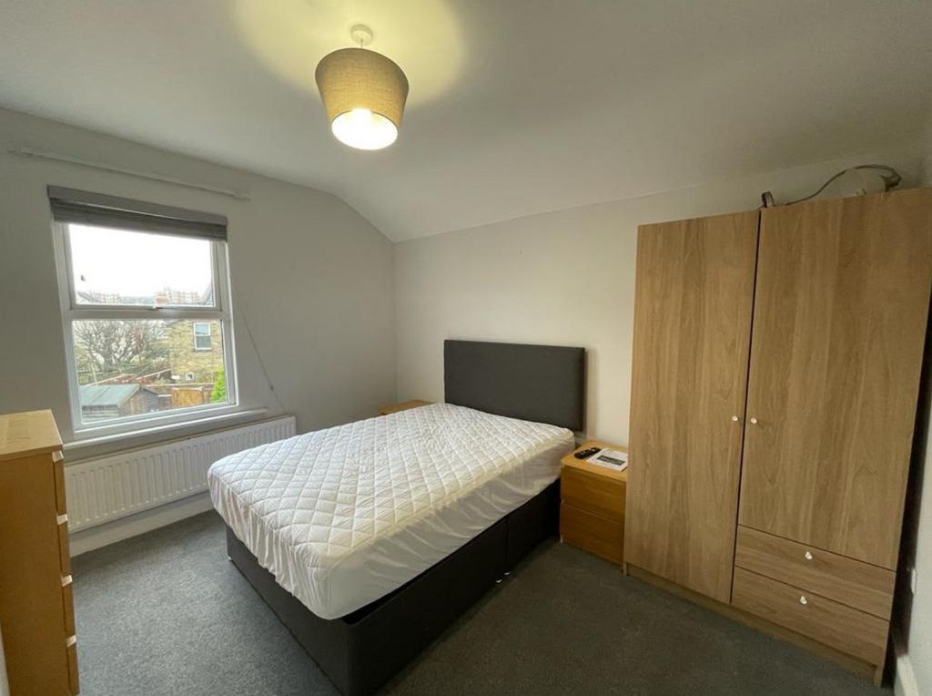 A clean and well lit double bedroom with a bed ...