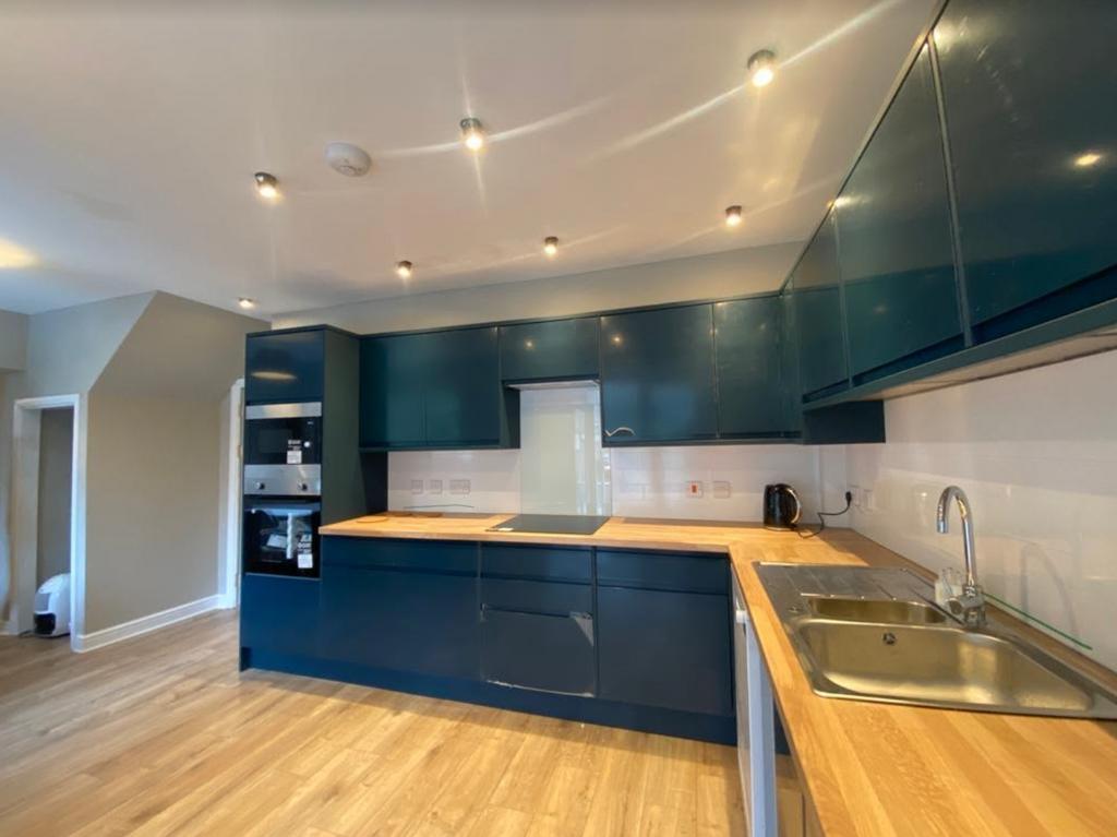 A modern and clean kitchen with blue cabinets a...