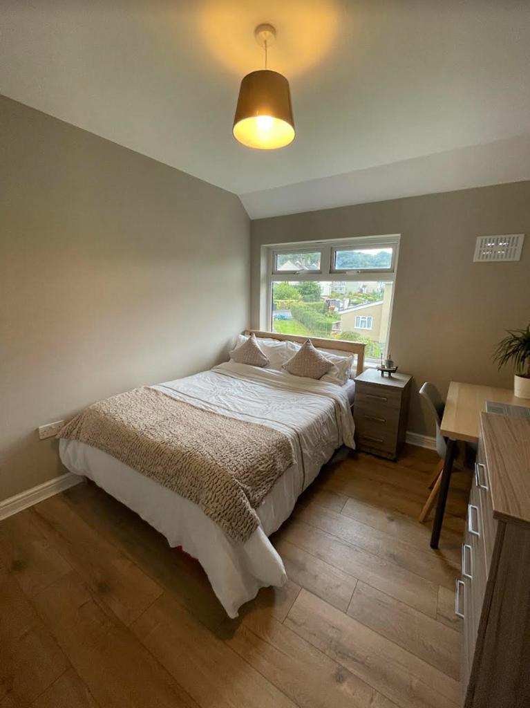 A clean and well lit double bedroom with a cozy...