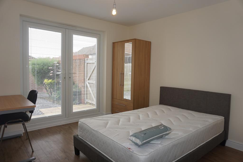 A bright and spacious double bedroom with garde...