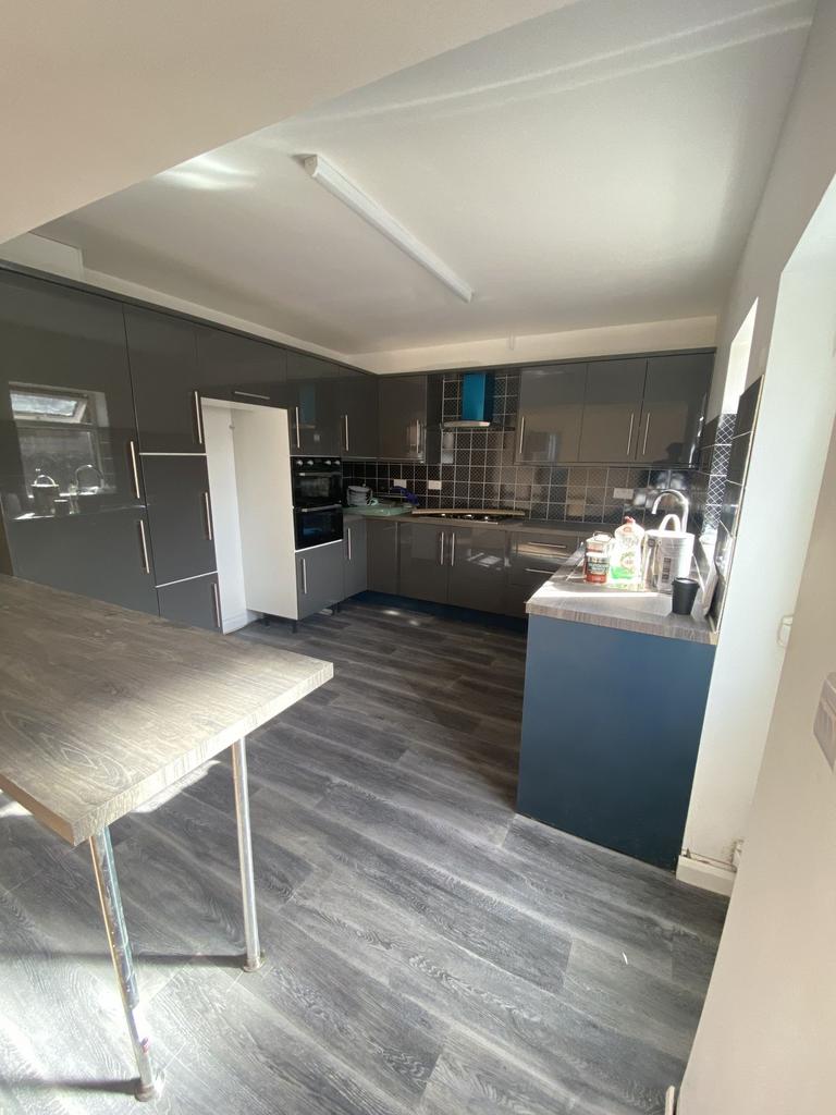Modern kitchen featuring sleek grey cabinetry w...