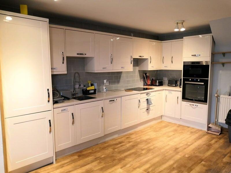 Modern, clean kitchen with white cabinets, ampl...