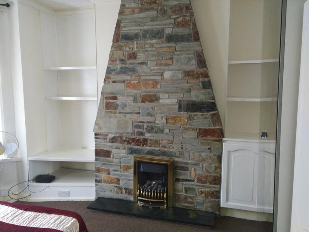 A cozy living room featuring a stone fireplace ...