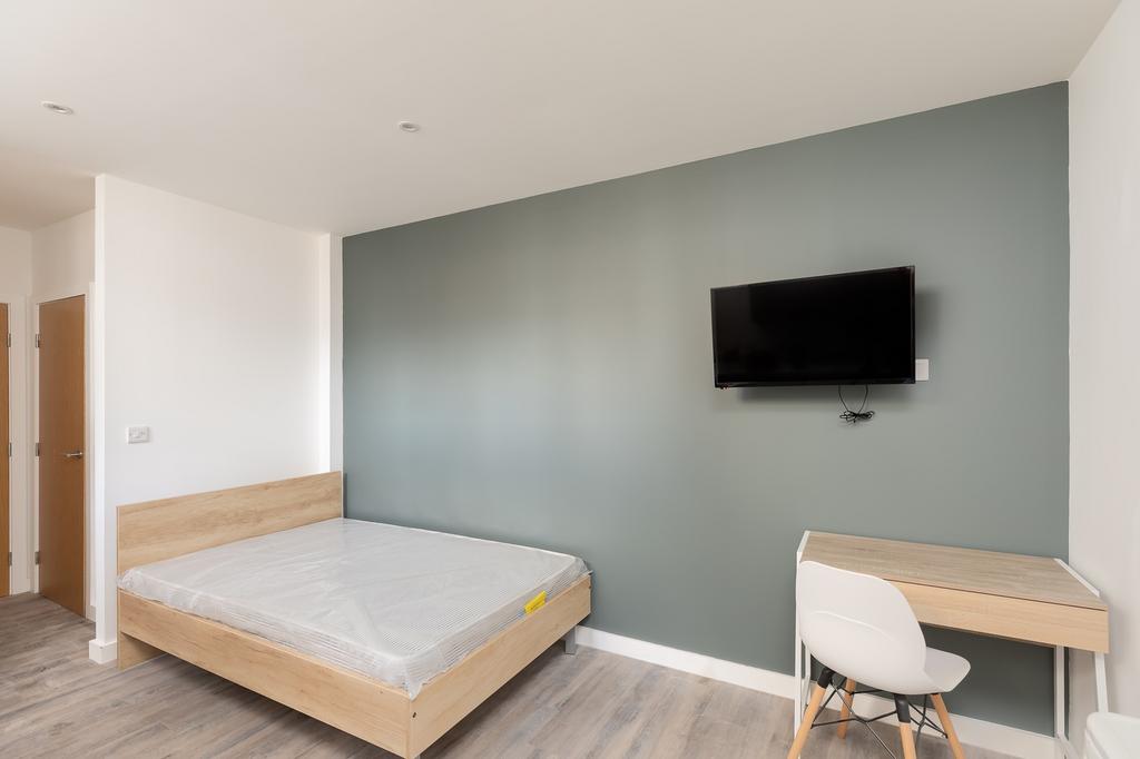 A spacious and modern double bedroom with a sty...