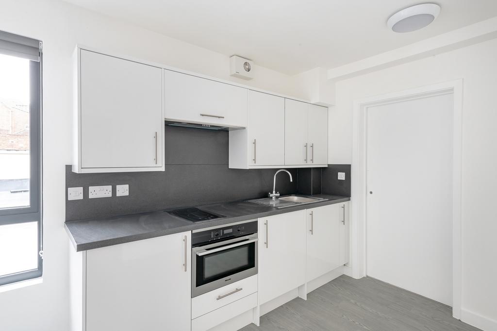 A modern and clean kitchenette with ample stora...