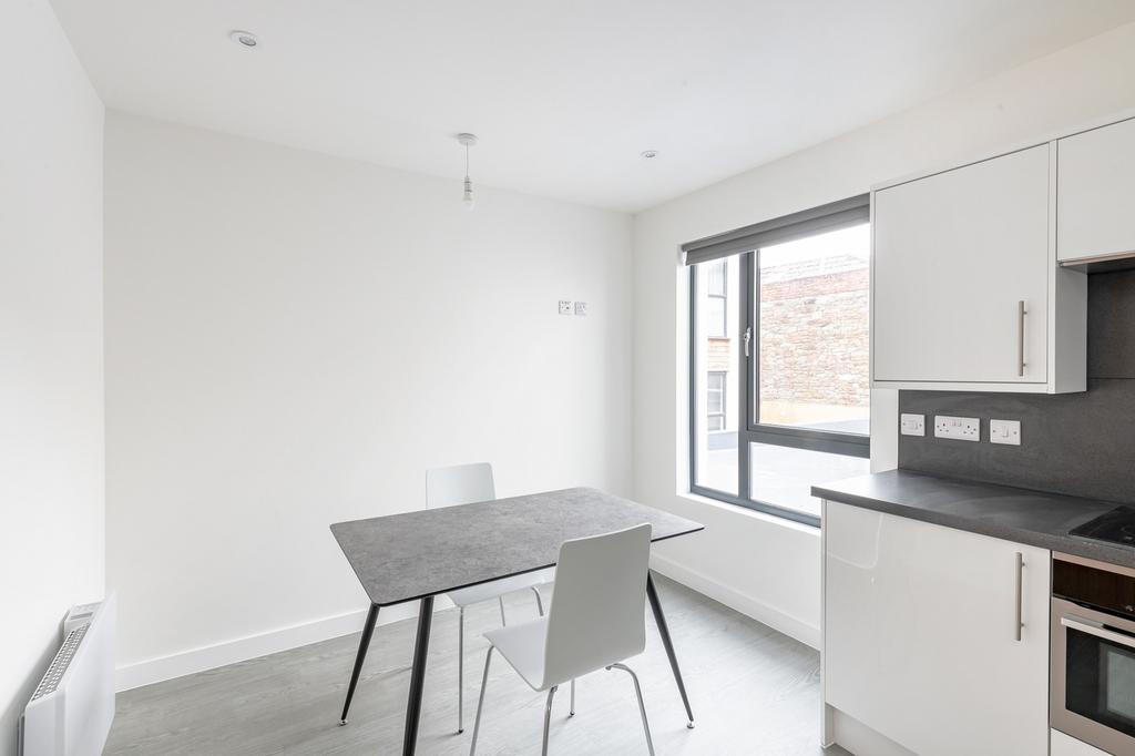 A bright and modern kitchenette featuring a sle...