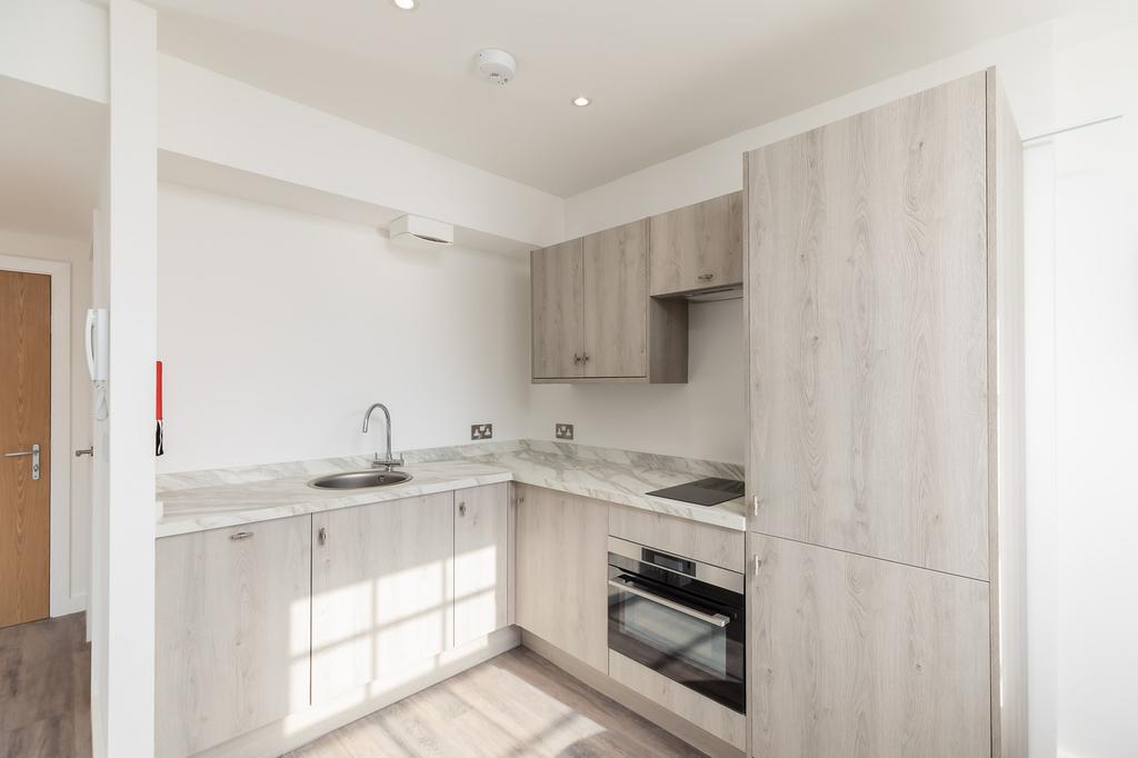 A modern and tidy kitchenette with ample natura...