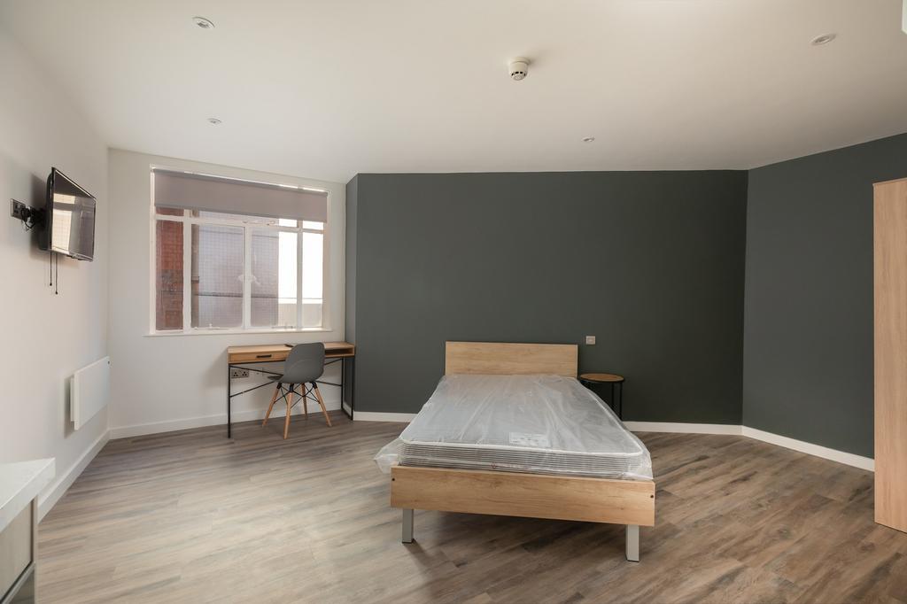 A spacious and well-lit double bedroom, perfect...