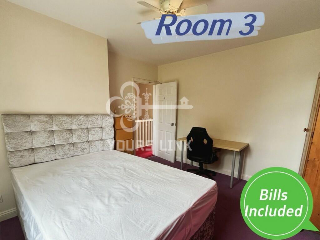 A spacious double bedroom with a comfortable be...