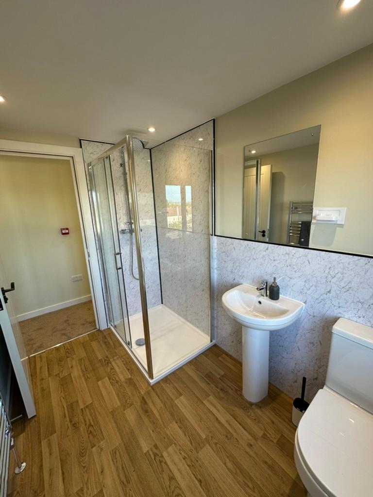 A spacious and modern bathroom featuring a slee...