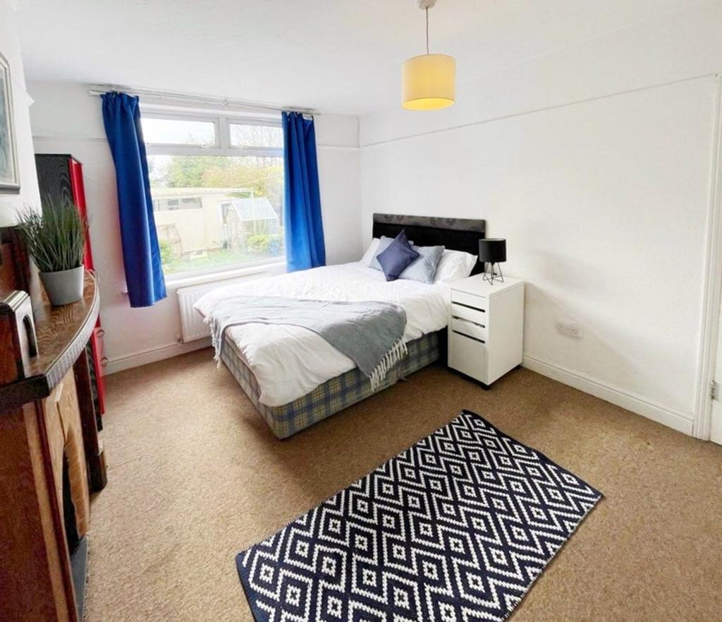 A bright and spacious double bedroom with moder...