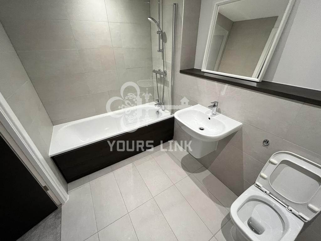 A spacious and modern bathroom featuring a styl...