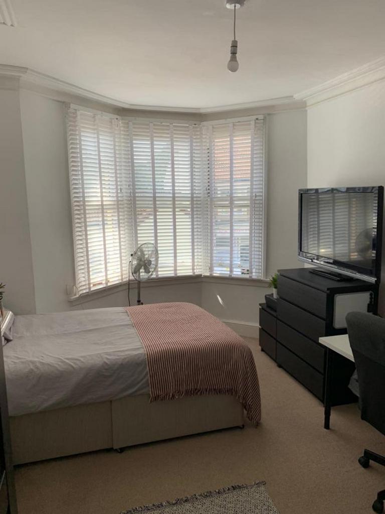 A clean and well lit double bedroom with large ...