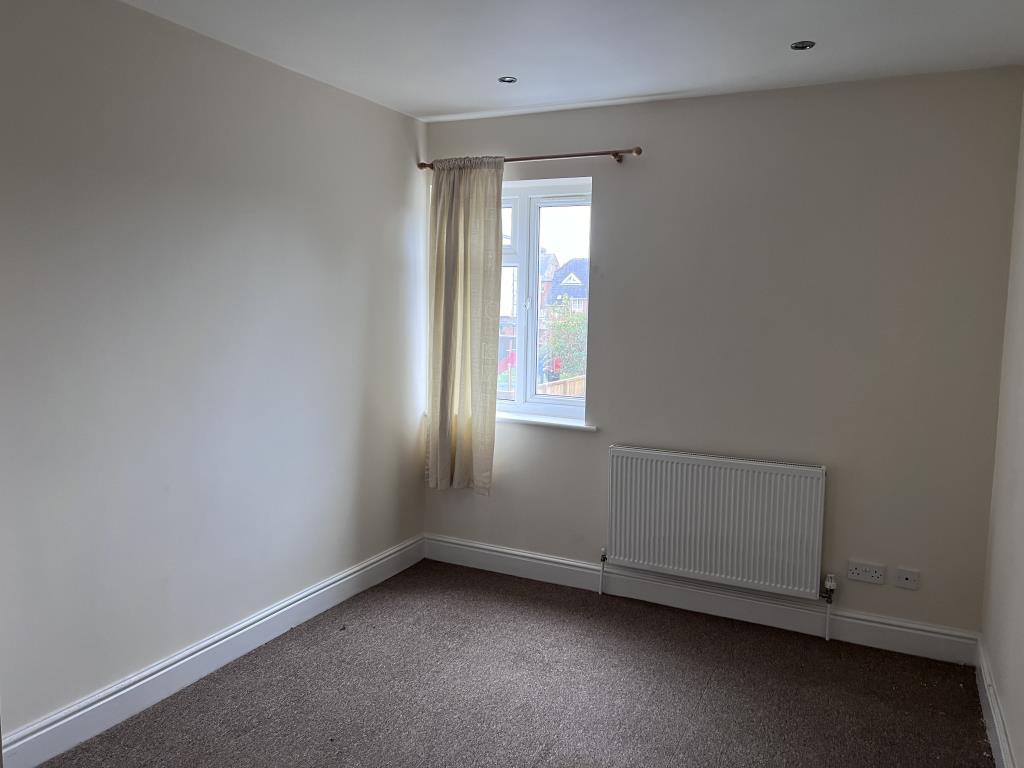 Bedroom three with magnolia walls and beige carpet