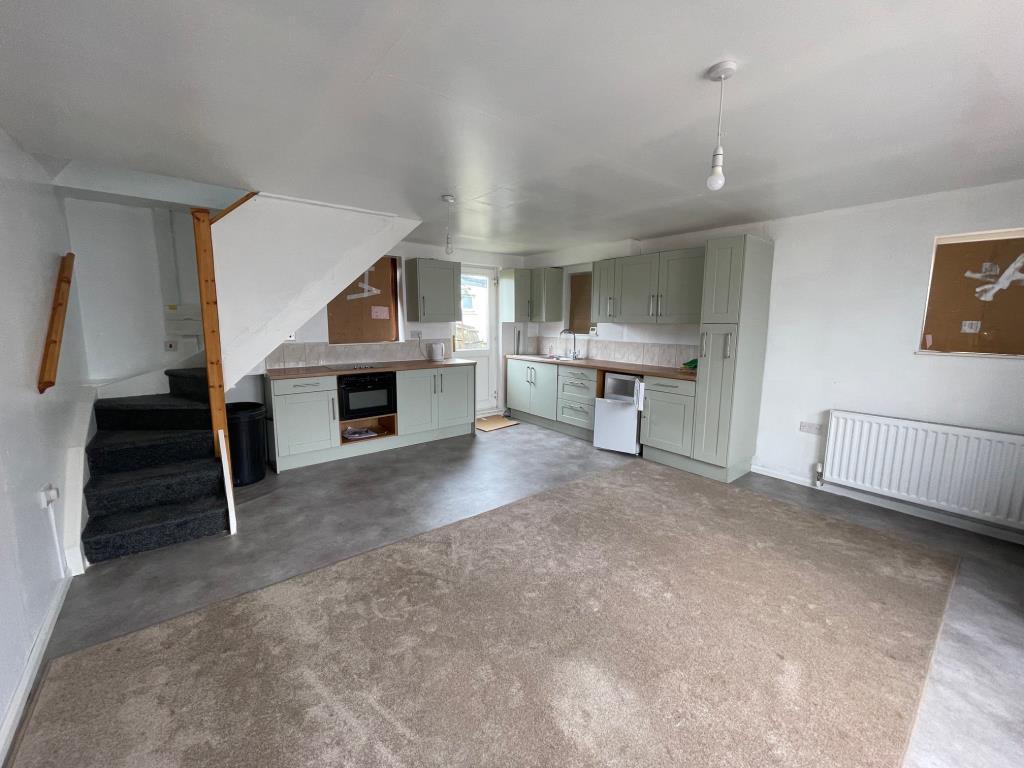 Open plan room with kitchen area back door and sta